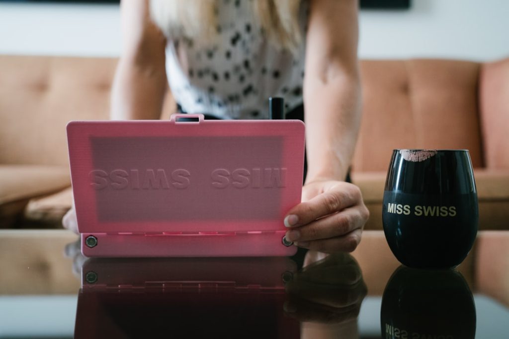 person holding pink plastic case