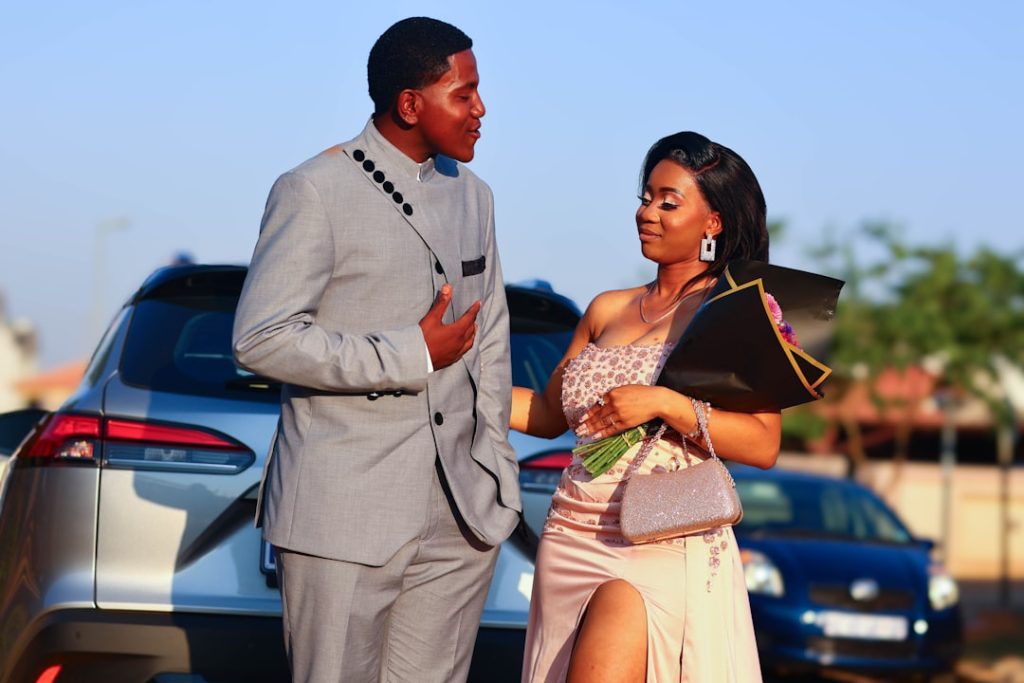 A man and a woman standing next to a car