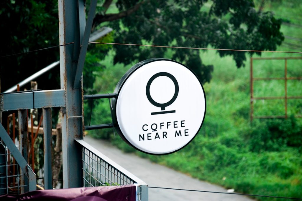 White circular sign with "coffee near me" text.