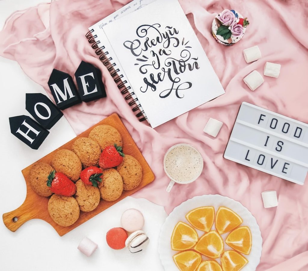 Cookies, fruit, and marshmallows with "food is love" sign.